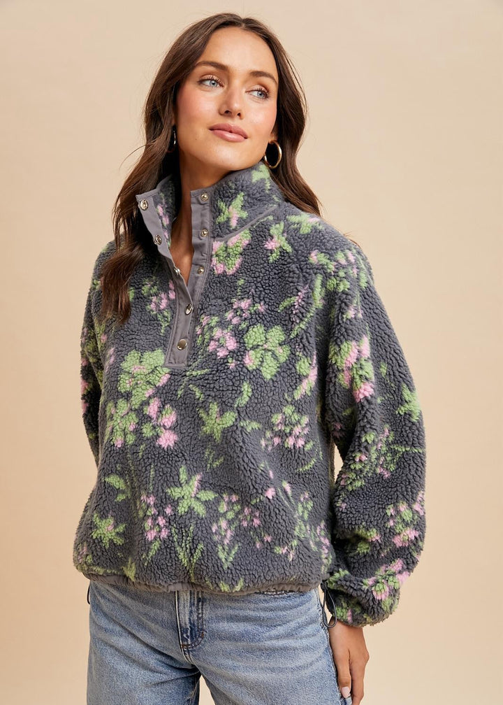 Woman wearing a floral-patterned fleece pullover against a beige background