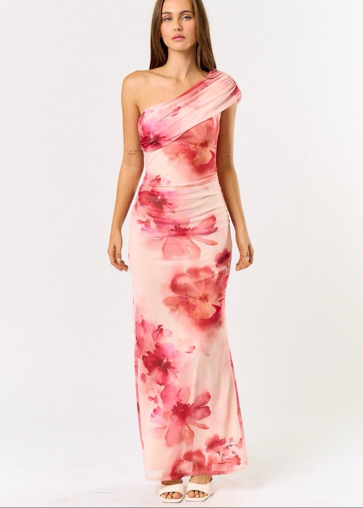 Woman wearing a pink floral one-shoulder dress on a white background