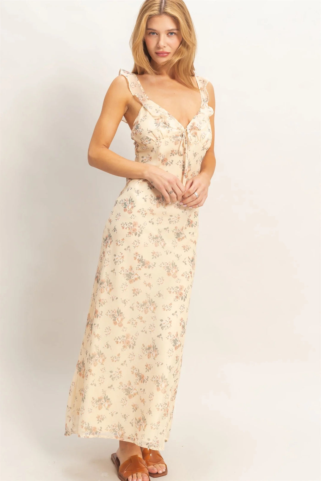 Woman wearing a floral dress against a plain background